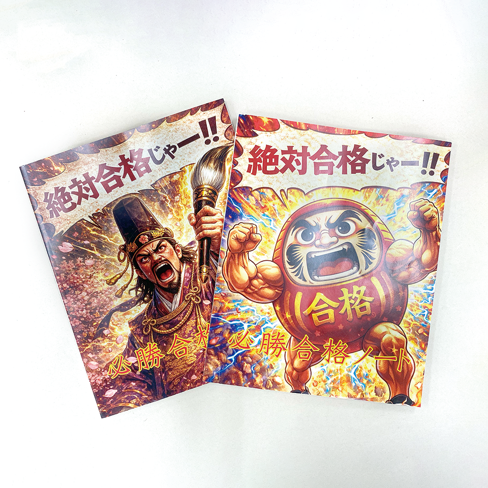 コミカルなタッチの菅原道真と、筋肉隆々のダルマのイラスト（AI生成）が印刷されたノート。「絶対合格じゃー!!」と叫んでいる。